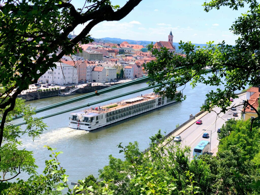 European river cruise ship gliding along a river with historic buildings in the background.